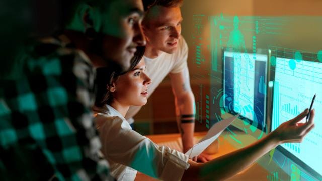 Gruppe junger Personen schauen auf Monitor 