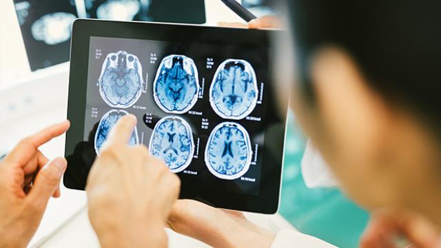 Arzt und Patient blicken auf Tablet mit CT-Ergebnissen
